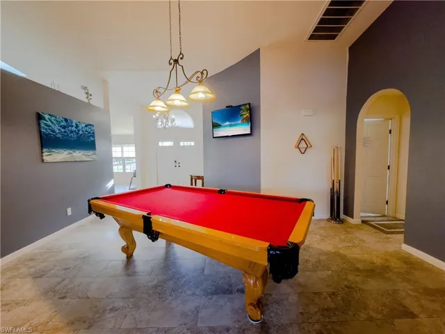 Recreation room with arched walkways, billiards, visible vents, and baseboards