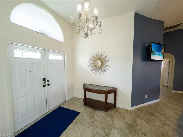 Entryway featuring an inviting chandelier, visible vents, and baseboards