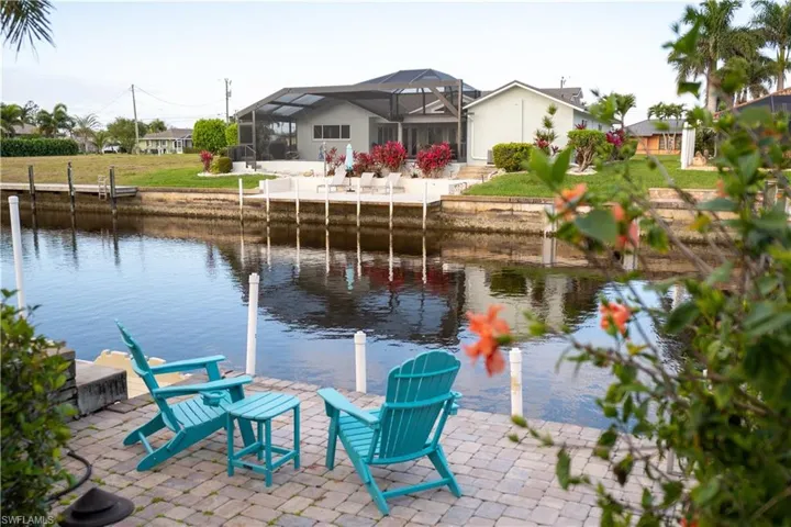 Dock area with a lanai, a water view, and a patio