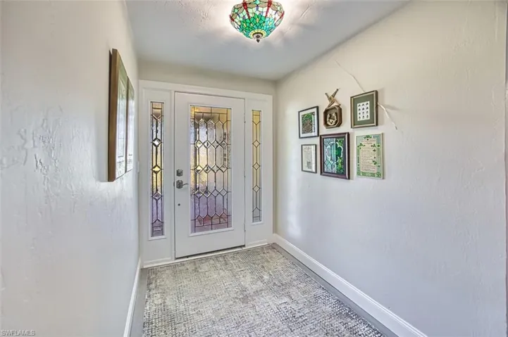 Foyer with baseboards and a textured wall