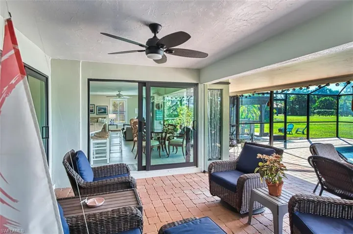 Sunroom / solarium featuring ceiling fan and a patio