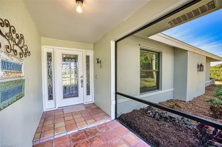 Doorway to property featuring stucco siding
