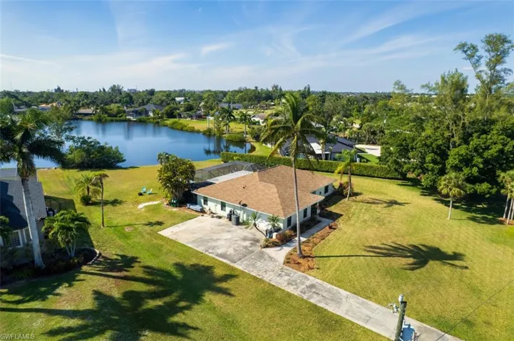 View of subject property featuring a large body of water and a tree filled landscape
