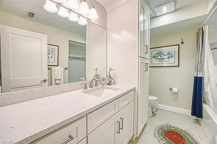 Bathroom featuring light tile patterned floors, shower / bath combo, and vanity