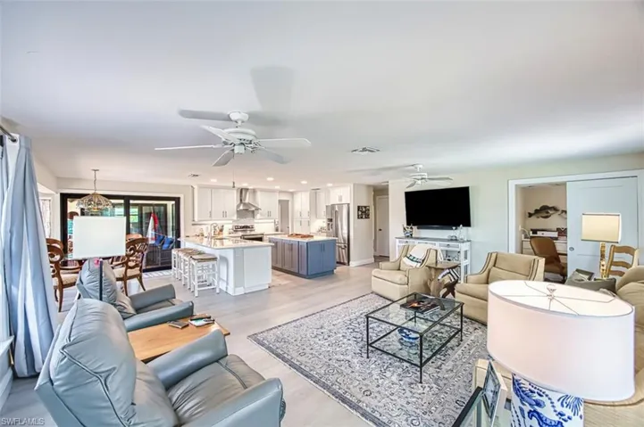 Living area with light wood-style flooring, recessed lighting, a ceiling fan, and a chandelier