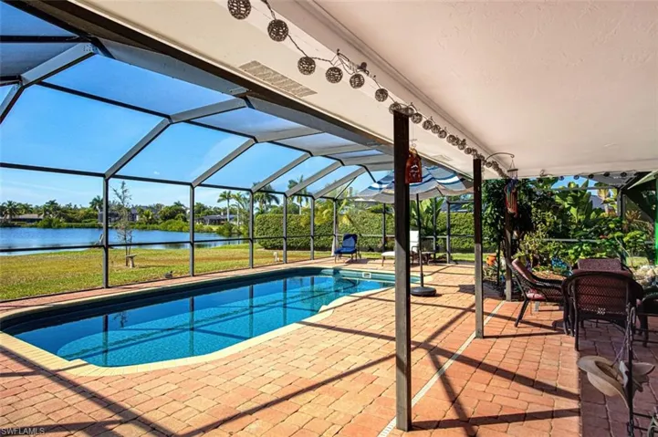 Outdoor pool featuring a lanai, a patio area, and a water view