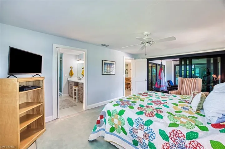 Bedroom with light carpet, ceiling fan, access to outside, and connected bathroom