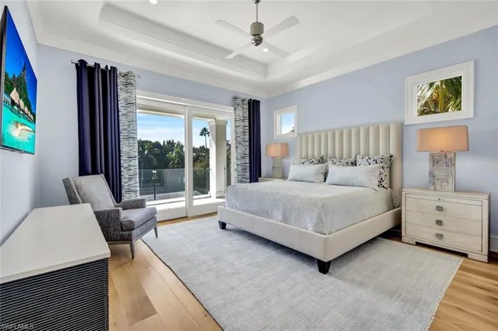 Bedroom with access to outside, light wood finished floors, and a ceiling fan