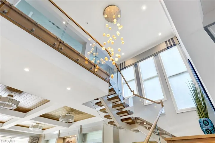 Stairs featuring coffered ceiling and recessed lighting