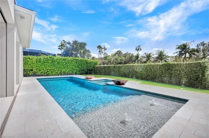 Combined pool / hot tub with a patio and a fenced backyard