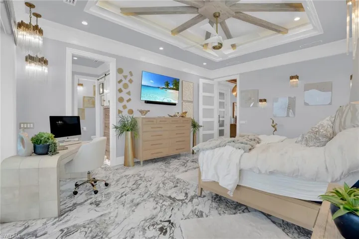 Bedroom featuring an office area, a ceiling fan, crown molding, marble finish floors, and coffered ceiling - Virtually Edited Image