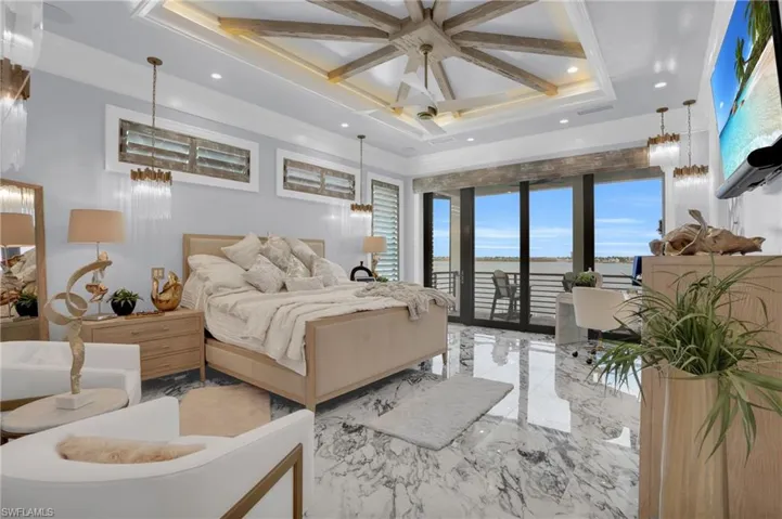 Bedroom with marble tiled flooring, access to outside, a chandelier, ceiling fan, and coffered ceiling - Virtually Edited Image