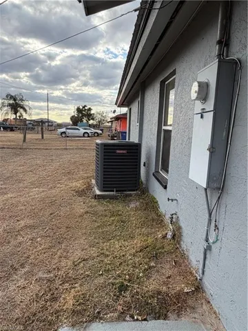 Exterior view of stucco siding and a central AC unit