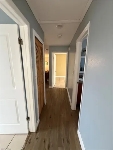 Hallway with baseboards and dark wood-style floors