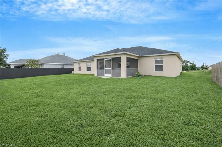 Rear view of property with a sunroom and stucco siding