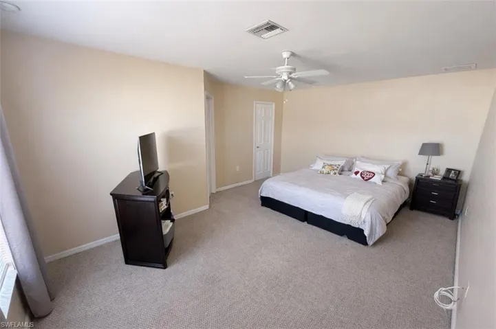 Bedroom featuring light colored carpet and a ceiling fan