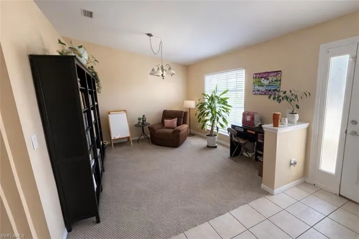 Office space with light carpet, light tile patterned flooring, and a chandelier