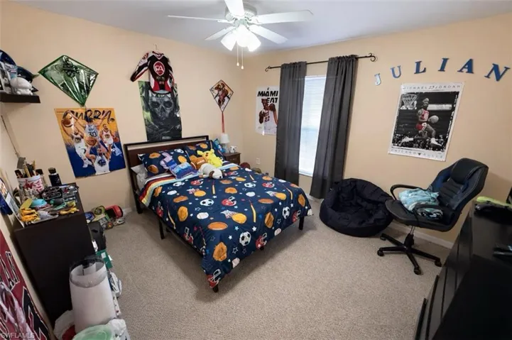 Carpeted bedroom featuring ceiling fan