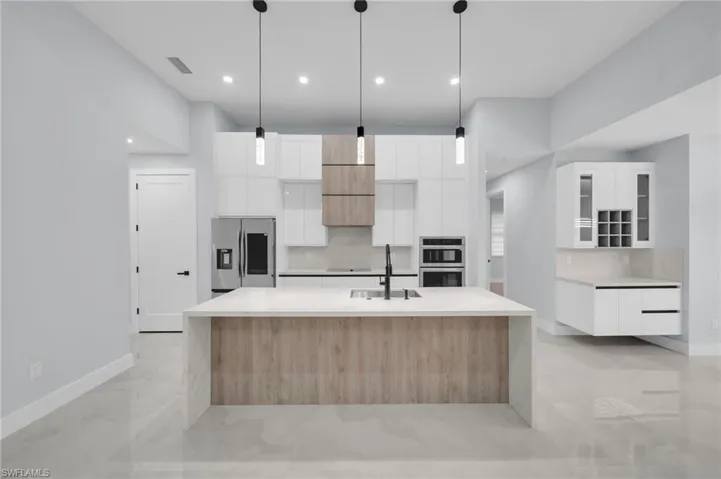 Kitchen with stainless steel appliances, tasteful backsplash, a sink, and modern cabinets