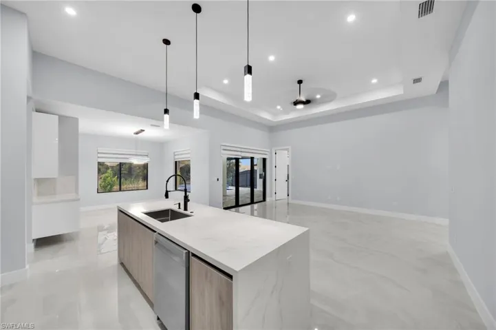 Kitchen with a raised ceiling, visible vents, a sink, modern cabinets, and dishwasher