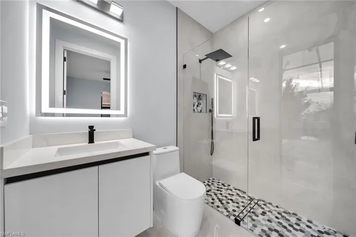 Full bath with vanity, a shower stall, and toilet