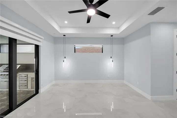 Unfurnished room featuring baseboards, visible vents, a raised ceiling, and recessed lighting