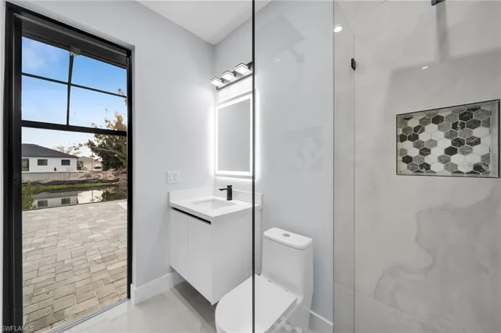 Full bath featuring a shower, vanity, toilet, and baseboards