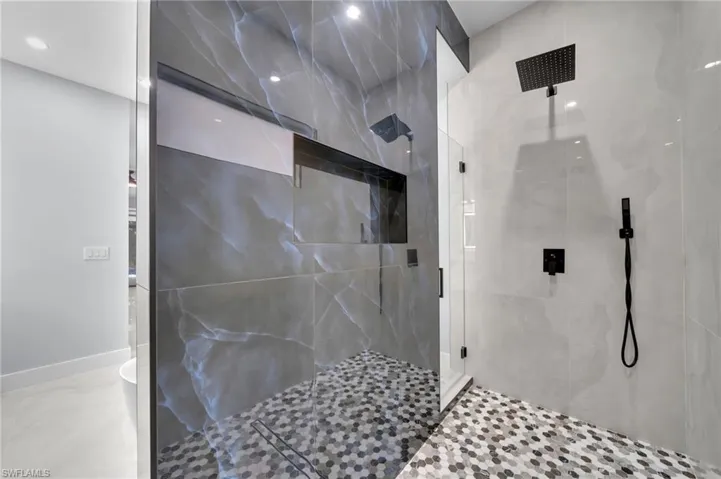 Bathroom featuring a shower stall and baseboards