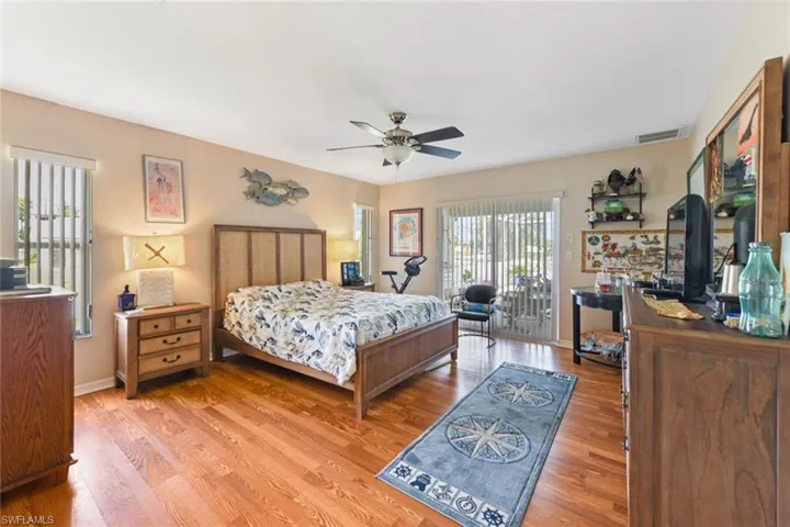 Bedroom featuring access to outside, wood finished floors, and ceiling fan