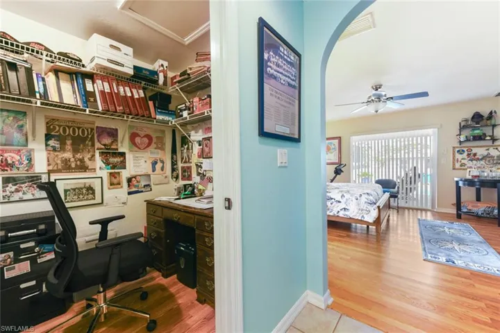 Office with light wood-style flooring and a ceiling fan