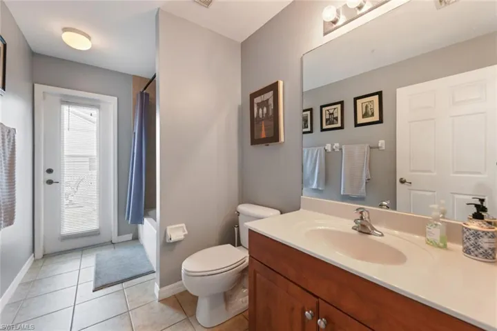 Bathroom featuring vanity, shower / bath combo, and light tile patterned floors