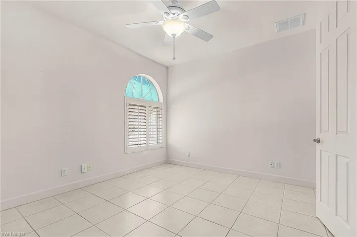 Spare room featuring ceiling fan and light tile patterned floors