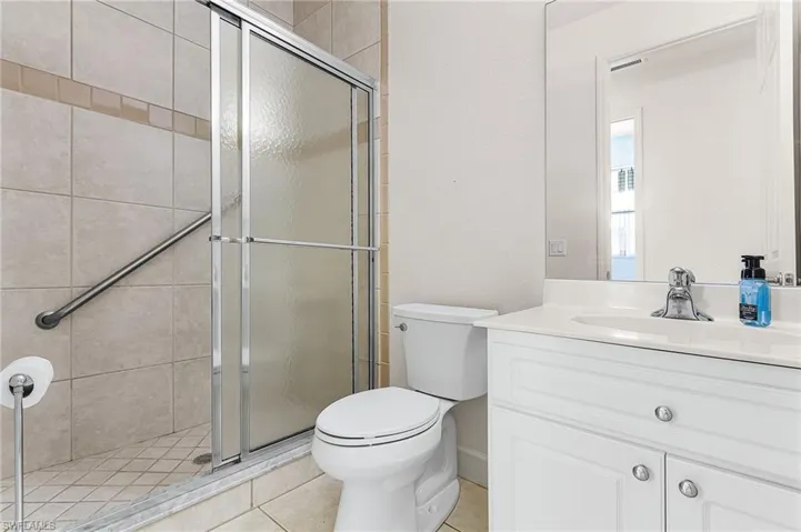 Bathroom featuring vanity, a shower stall, and light tile patterned floors