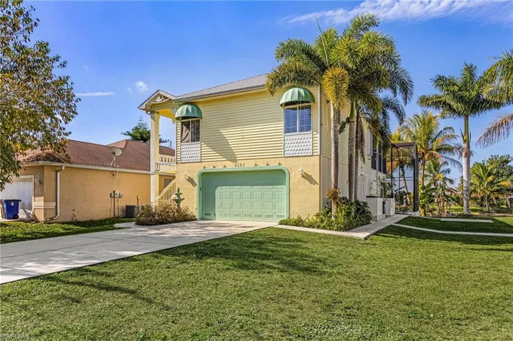 View of front of home featuring concrete driveway, a balcony, a front yard, and an attached garage