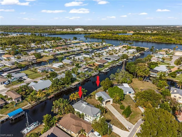 Aerial view of property's location featuring a large body of water and nearby suburban area