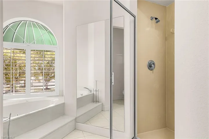 Bathroom featuring a bath, a shower stall, and light tile patterned floors