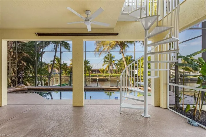 Swimming pool featuring a patio, a lanai, a water view, and stairway