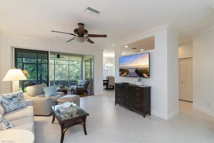 Living room with crown molding, light tile floors, and open concept light and bright and perfect for entertaining.