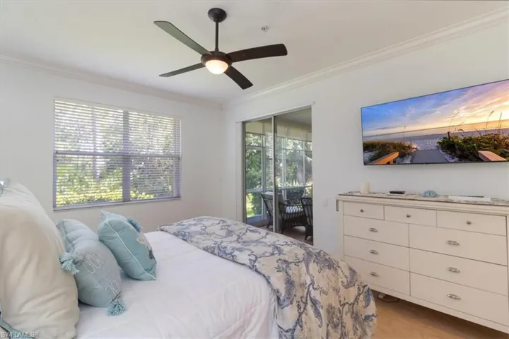 Bedroom with access to outside, ornamental molding, ceiling fan, and light hardwood / wood-style flooring