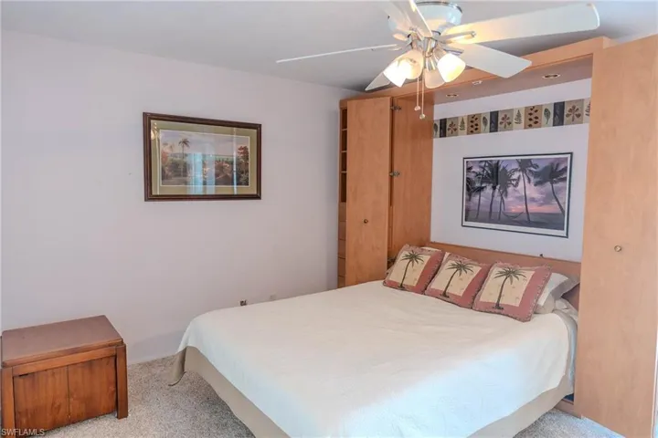 Carpeted bedroom featuring a ceiling fan