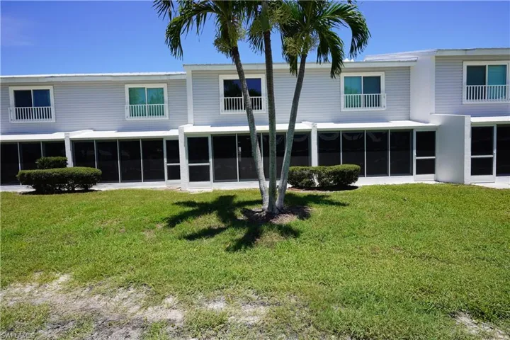 Rear view of property featuring a sunroom and a yard