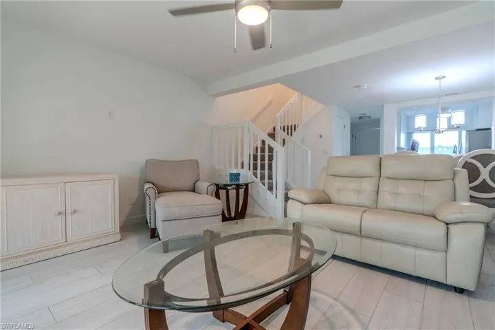 Living room featuring stairway, a ceiling fan, and wood finish floors