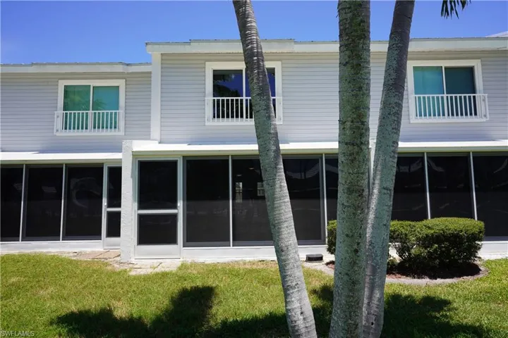 Back of house featuring a lawn and a sunroom