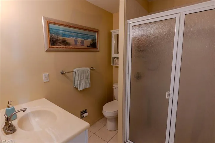 Bathroom with vanity, a stall shower, and light tile patterned flooring
