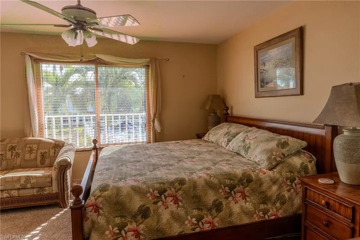 Carpeted bedroom with a ceiling fan