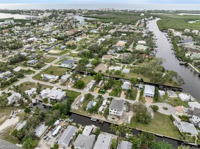 Aerial overview of property's location featuring a nearby body of water and nearby suburban area