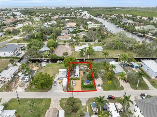 Aerial view of residential area with property parcel outlined and a large body of water