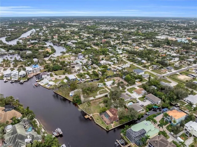 Aerial view of property's location with a nearby body of water and nearby suburban area