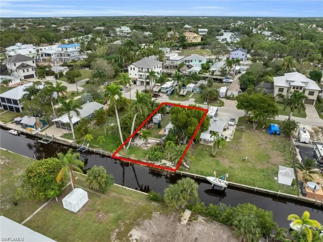 Aerial perspective of suburban area featuring property boundaries highlighted and a nearby body of water