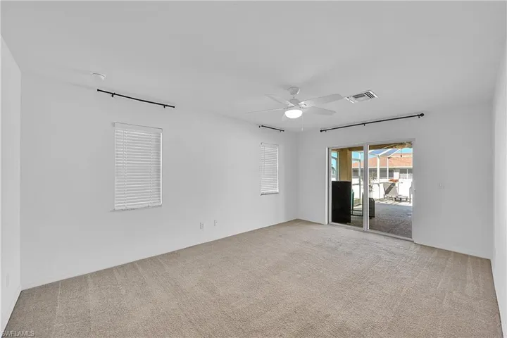 Empty room featuring light colored carpet and ceiling fan